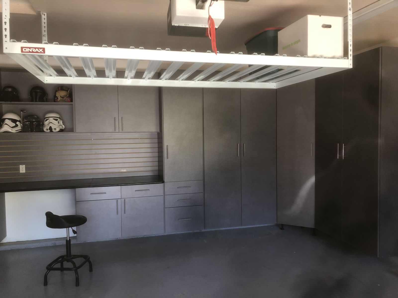 Overhead storage rack with built-in garage cabinets and workbench