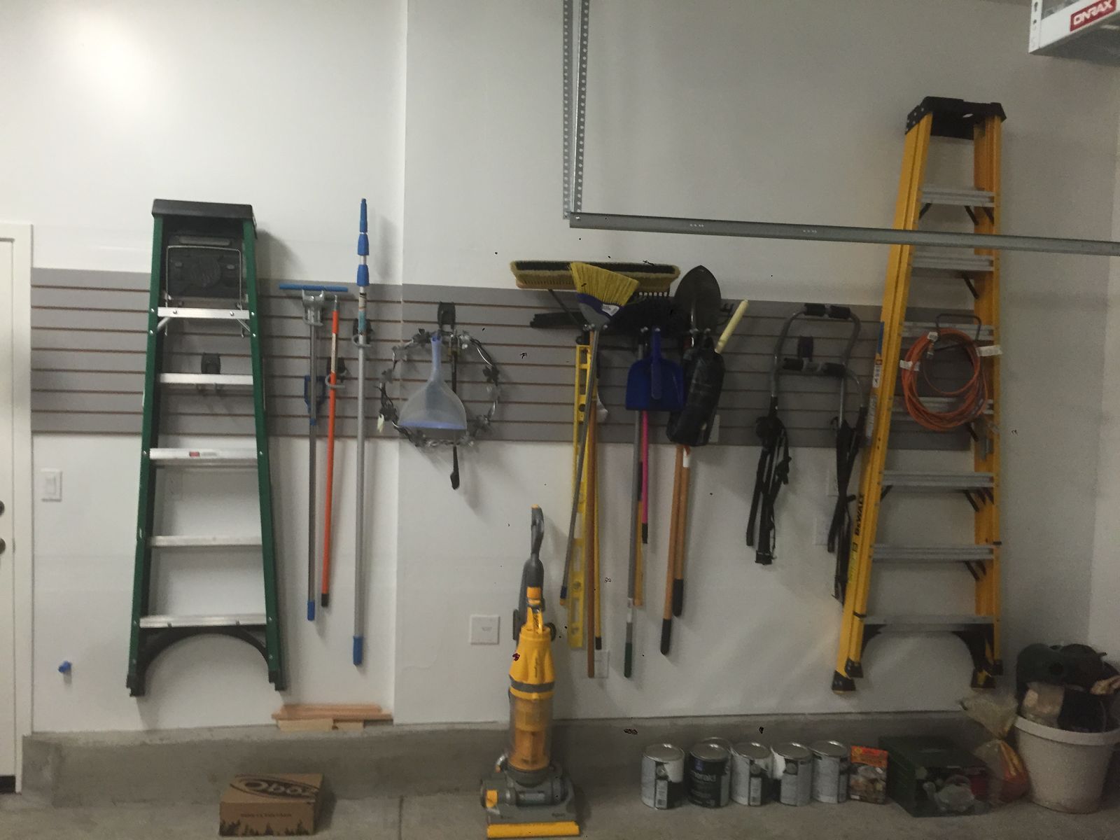Slatwall tool wall with ladders and yard tools